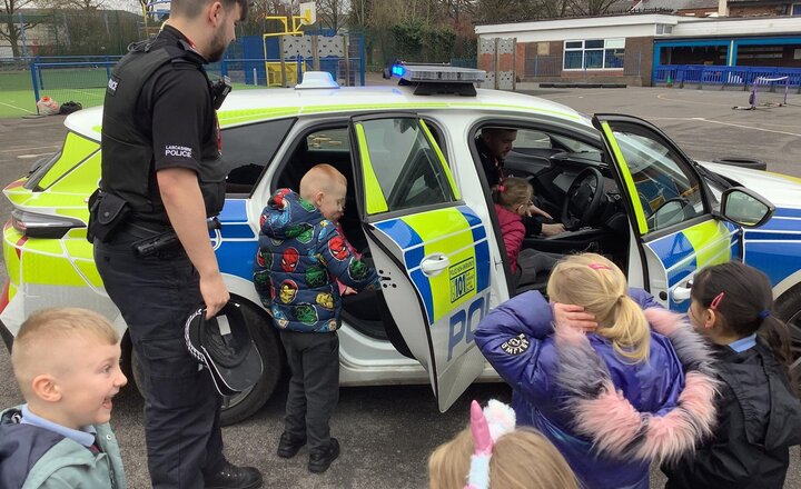 Image of Continuing our people who help us theme, we had a visit from PC Wilcock and PC Greenhalgh from Blackburn Police.  The children enjoyed experimenting with all the clothing and equipment.  We also got to sit in he car and turn the lights and sirens on.