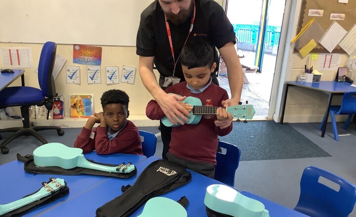 Image of Today in Music with Junior Jam, the children are being taught how to play the ukulele. We've been focusing on the correct way to hold it and practising strumming the strings to create a melody.
