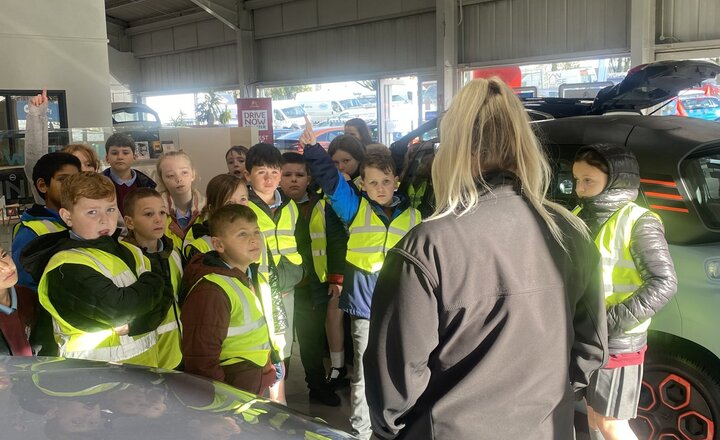 Image of Year 5 visit car showroom as part of a writing experience day. 